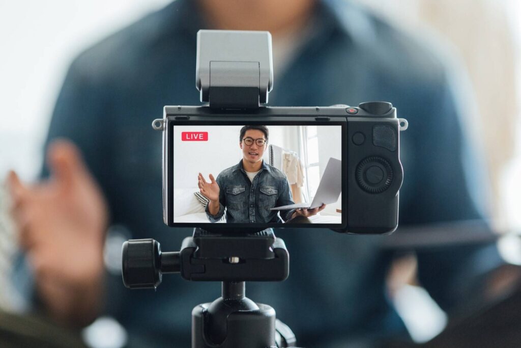a man talking in front of a camera on live recording