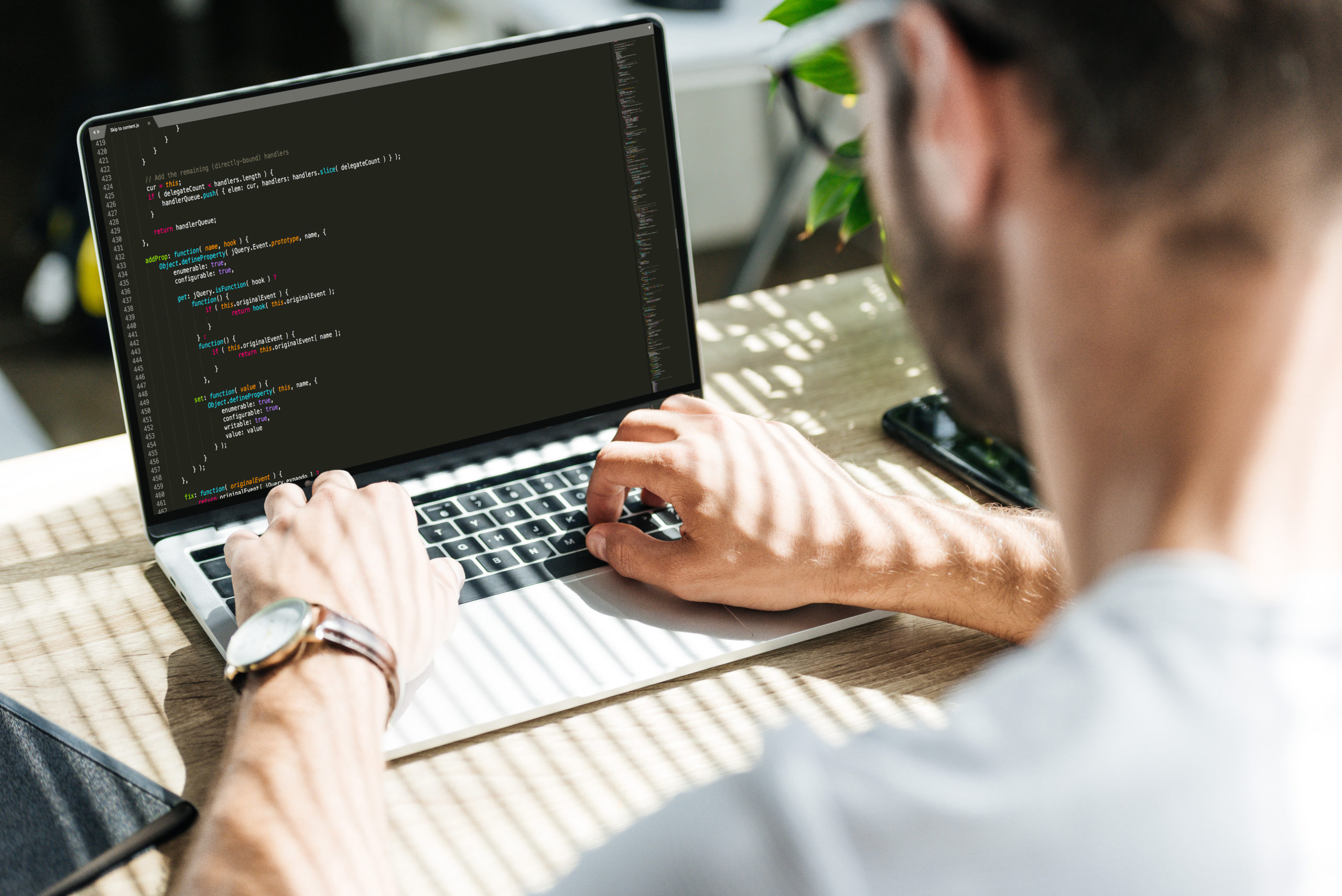 a man coding on a laptop